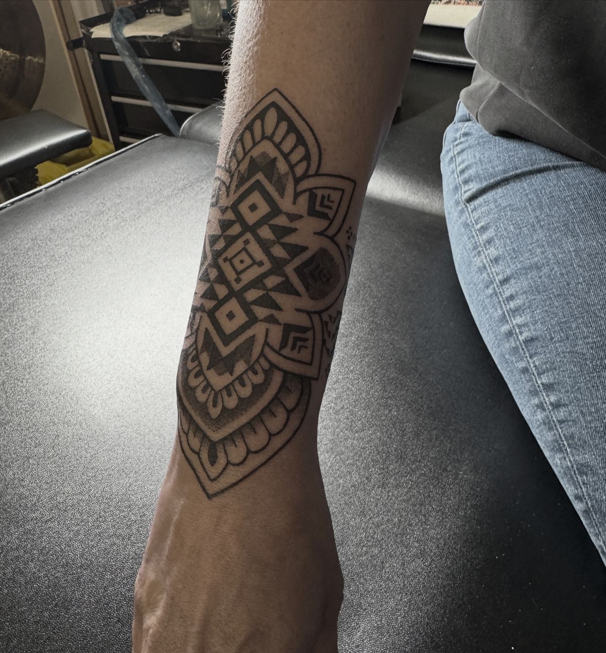 Tatouage vibratoire nettoyage, mandala ornemental aux losanges géométriques sur l'avant-bras et le poignet